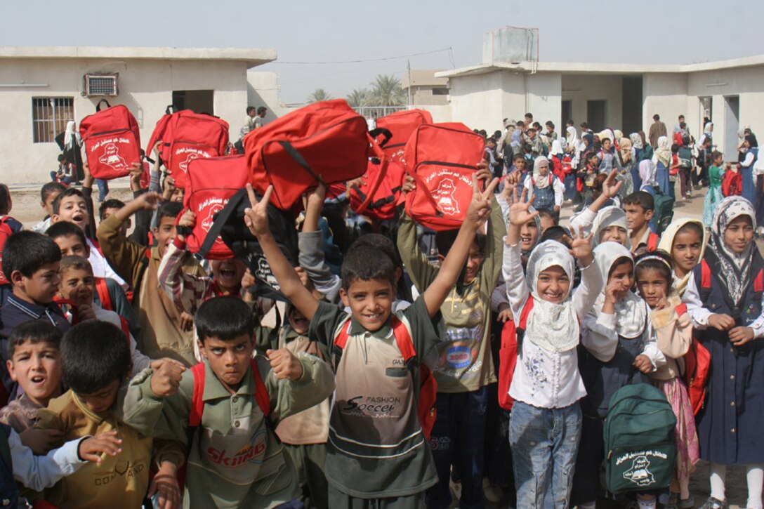 051018-M-2607O-005 KARMAH, Iraq - Students from the Thorouh Al Aashreen Primary School show off their thanks and new backpacks provided by 6th Civil Affairs Group after the official opening ceremony Oct. 18.  Over 800 backpacks were handed out during the ceremony that day.