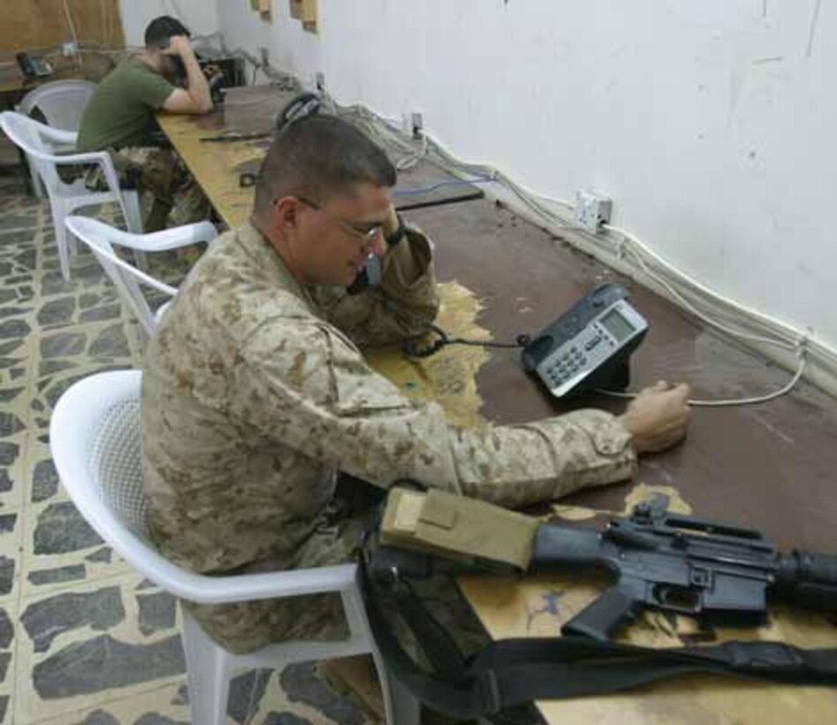 Sergeant David J. Navarre, an armorer with 2nd Battalion, 6th Marines calls home from the phone center on Camp Baharia. The phone center stays open 24 hours a day; 7 days a week due to the dedicated support of the corpsmen who man the front desk and make sure every Marine gets a chance to use the phone or computer.