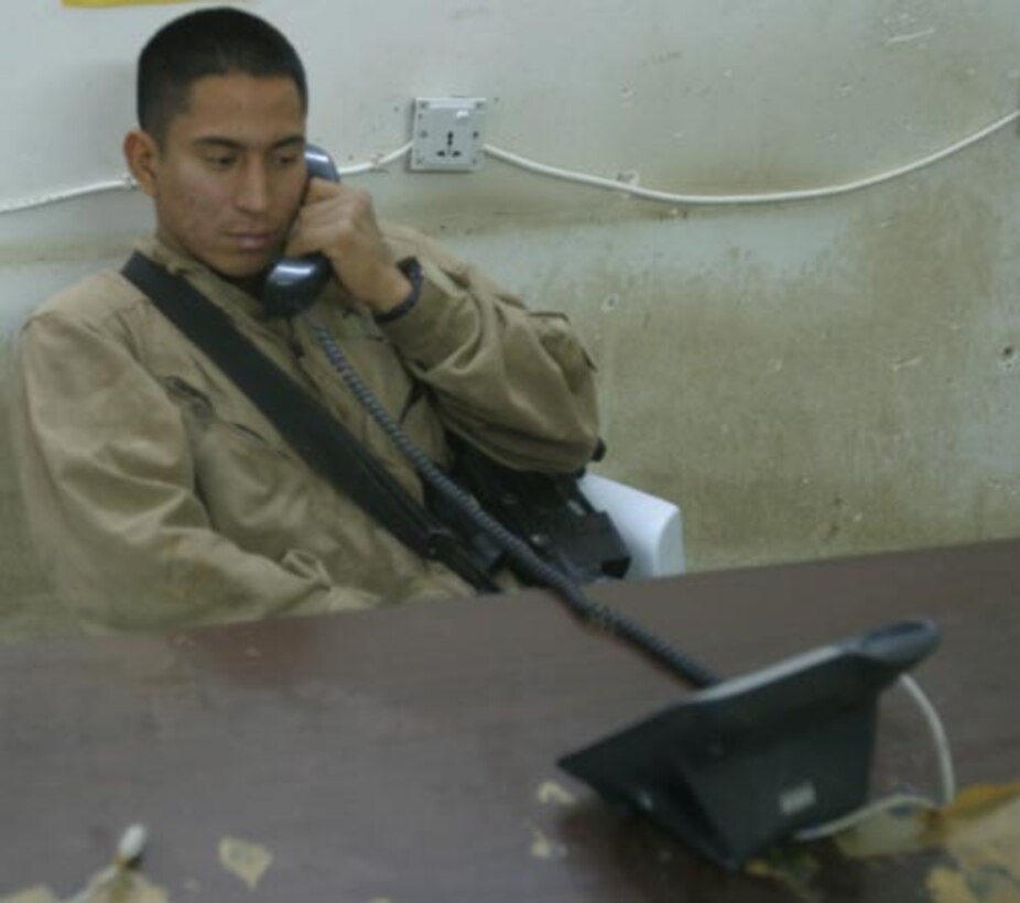 Private First Class Teddy J. Cardenas, an 18-year-old West New York, New Jersey native deployed with 2nd Battalion, 6th Marines calls home from the phone center on Camp Baharia. The phone center stays open 24 hours a day; 7 days a week due to the dedicated support of the corpsmen who man the front desk and make sure every Marine gets a chance to use the phone or computer.