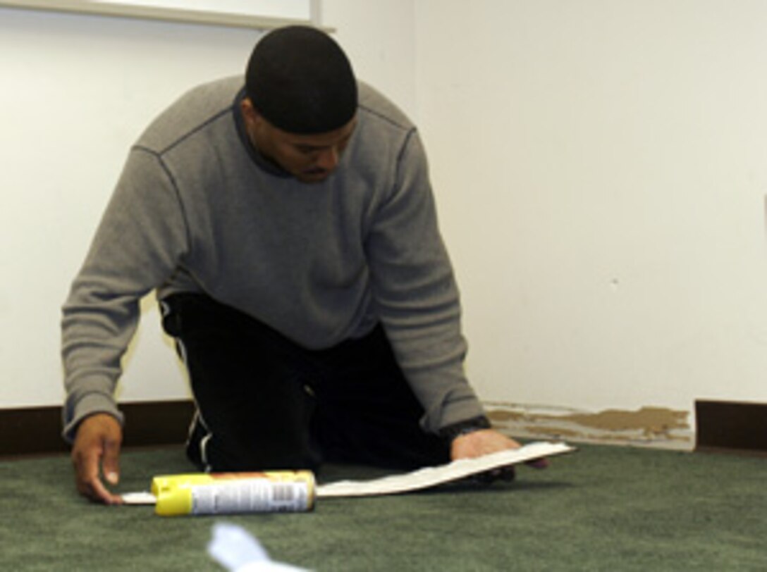 Staff Sgt. Sharrief Serra, machine gun section leader, A Company, 1st Battalion, 2nd Marine Regiment, replaces trim after having new carpeting installed in an area of the Religious Education Center in Tarawa Terrace II, Camp Lejeune, used for Muslim services. The funds for the carpeting were donated by Lance Cpl. Shane Trimbur, data communication specialist, 6th Marine Regiment, and his wife, Nisa Al-Sheikh October 14.