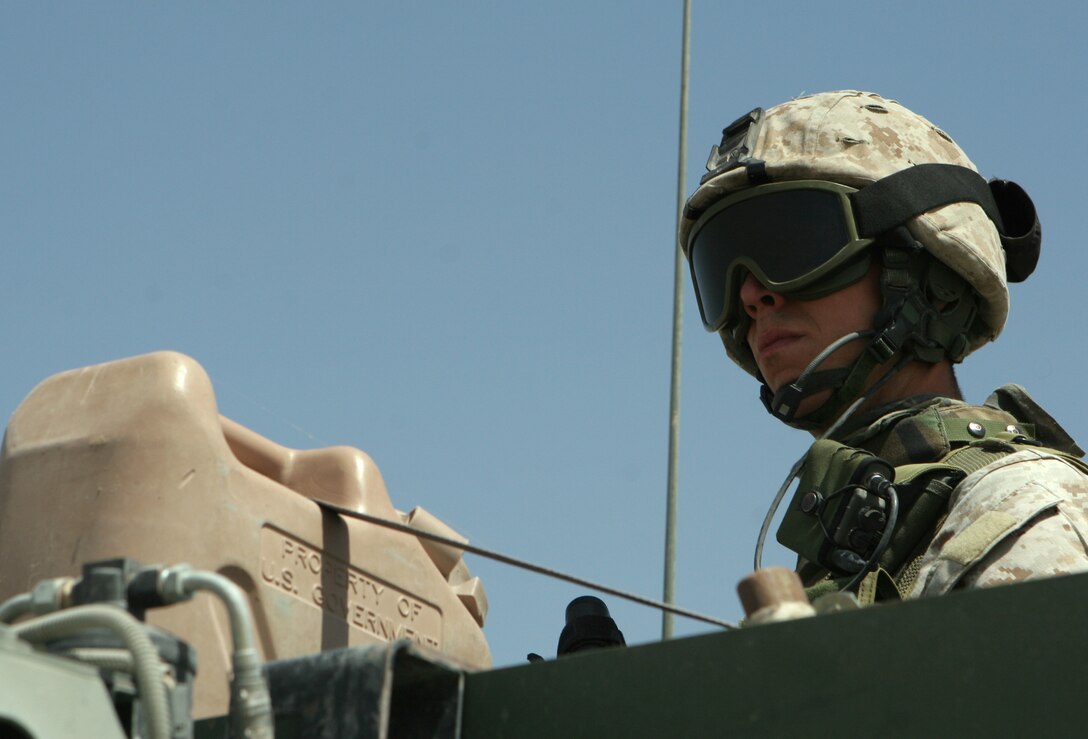Sergeant Daniel C. Duff, radio operator, Team 3, Detachment 2, 5th Civil Affairs Group, 2nd Marine Division, provides security during a recent convoy through Fallujah, Iraq. The Manassas, Va., native, who is on his second enlistment in the Marine Corps, works with the 5th CAG carrying out projects to promote growth and stability of the Iraqi community.