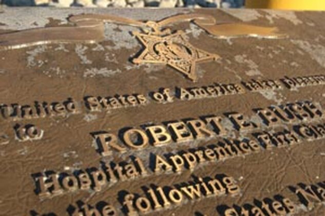 Inscribed on a large bronze plaque, the Congressional Medal of Honor citation of Robert E. Bush is displayed in front of a large cast bronze statue of his heroic acts on the island of Okinawa in 1945 outside the Robert E. Bush Naval Hospital.  Bush, who passed away Nov. 8, was honored by hospital staff and guests at a memorial service Nov. 18.