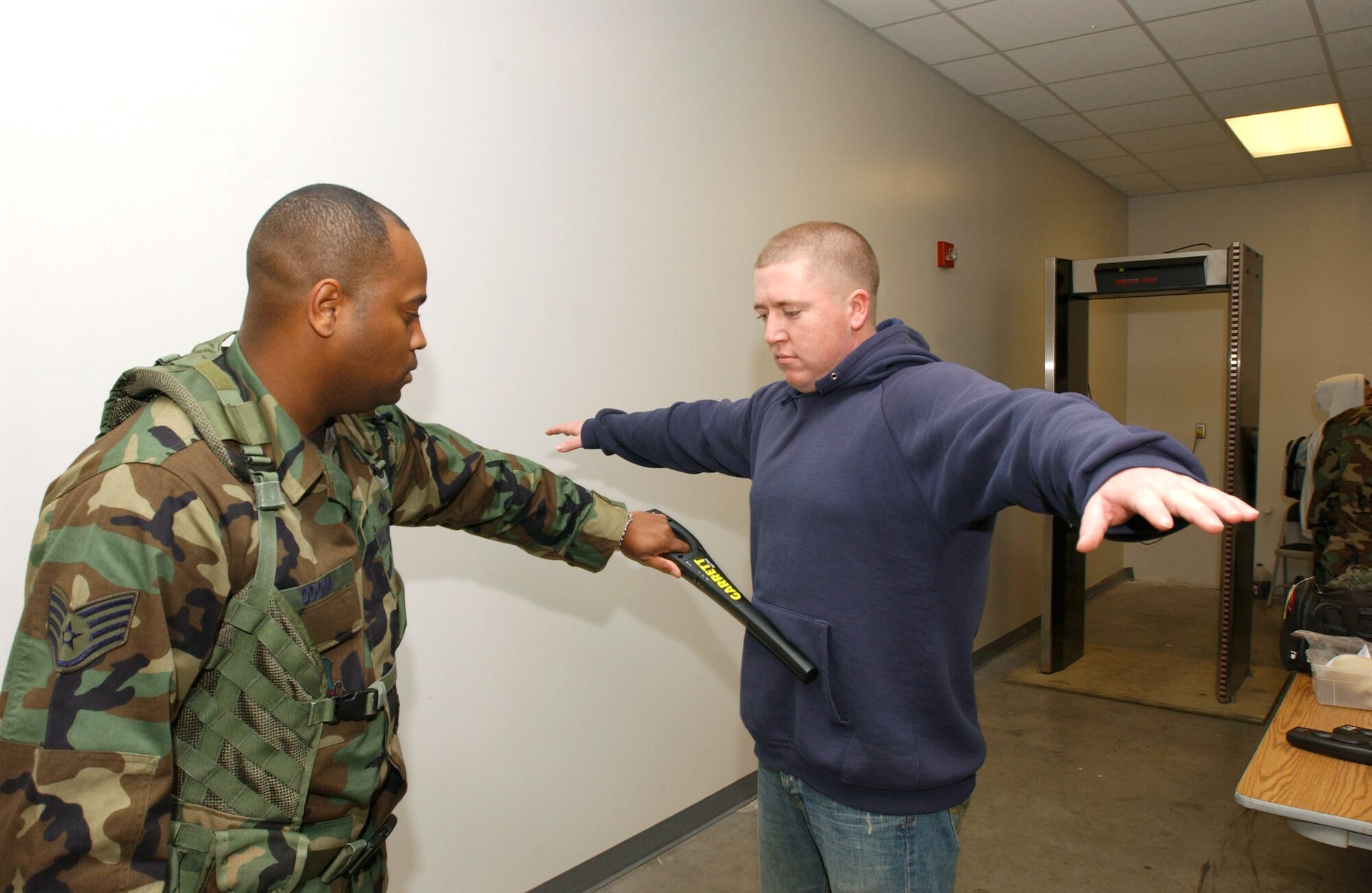 WHITEMAN AIR FORCE BASE, Mo. -- Staff Sgt. Patrick Odom checks Senior Airman Robert Frost of the 319th Operations Support Squadron from Grand Forks Air Force Base, N.D. prior to his boarding an aircraft here.  The aggregation is an experimental mobility concept set up by U.S. Central Command Air Force officials to establish a centralized point to provide better support for deploying Airmen.  Sergeant Odom is assigned to the 509th Security Forces Squadron.  (U.S. Air Force photo by Staff Sgt. Tia Schroeder)
