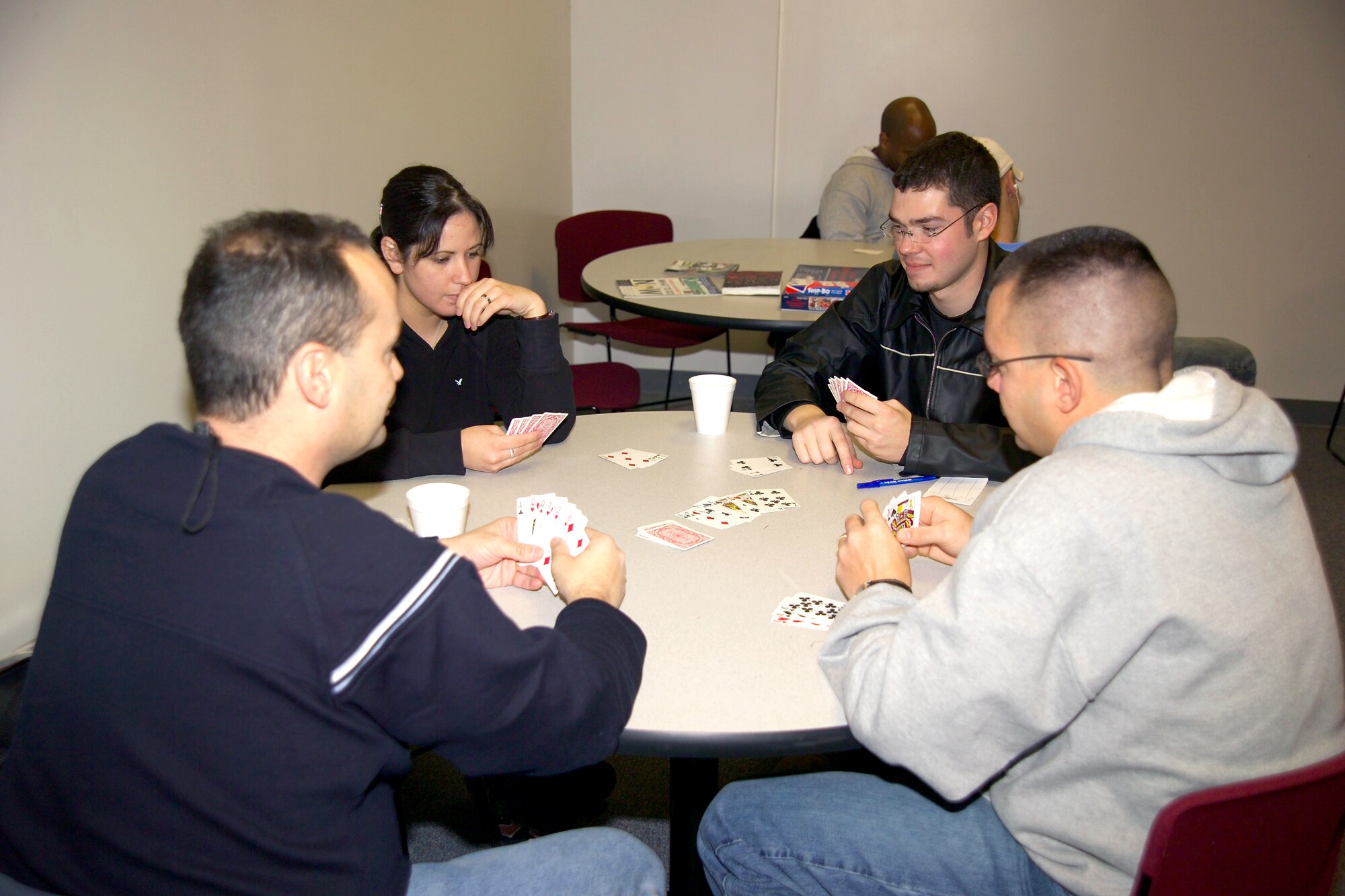WHITEMAN AIR FORCE BASE, Mo. -- Airmen from F.E. Warren Air Force Base, Wyo., play cards to pass the time while waiting for transportation at the deployment center here.  Airmen also had the opportunity to watch television and eat at the deployment center before boarding planes to go to locations in Southwest Asia.  (U.S. Air Force photo by Airman 1st Class Lauren Padden)
