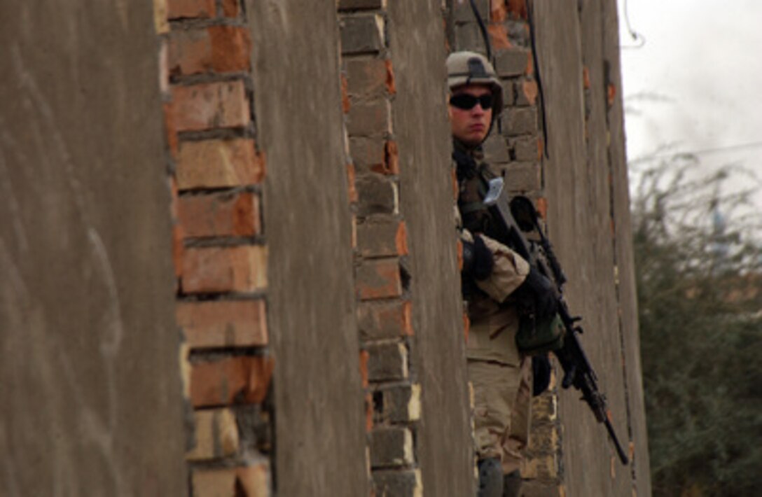 U.S. Army Pfc. Sheely keeps an eye out for suspicious activity during an assessment of various sites in Bayji, Iraq, on Jan. 6, 2005. Sheely is assigned to 1st Battalion, 26th Infantry Regiment, 2nd Brigade, 1st Infantry Division, attached to C Battery. 