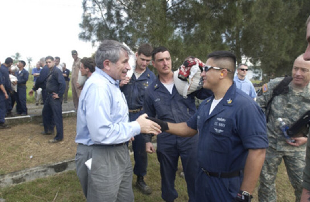 Deputy Secretary of Defense Paul Wolfowitz shakes hands and talks with sailors handling relief supplies at Banda Aceh, Indonesia, on Jan. 15, 2005. Wolfowitz is in Banda Aceh to meet regional commanders and thank the U.S. service men and women who are providing humanitarian assistance to areas devastated by the Dec. 26, 2004, Indian Ocean tsunami as part of Operation Unified Assistance. 