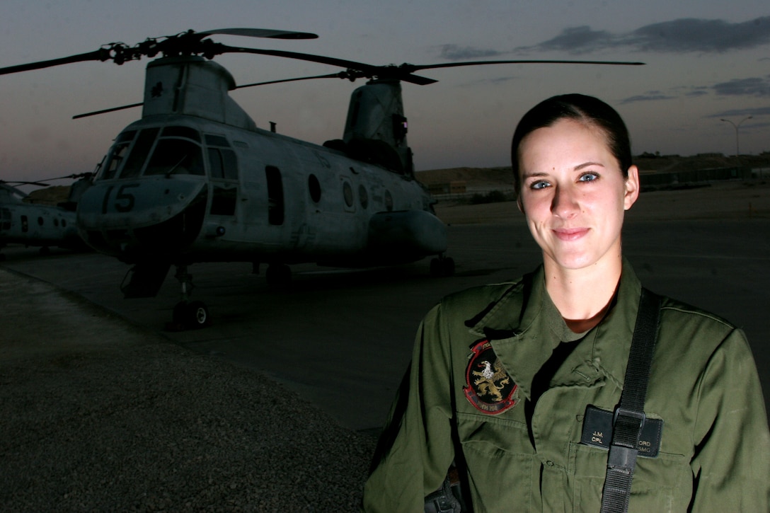 Cpl. Jessica M. Hereford, an avionics technician with Marine Medium Helicopter Squadron 266, stands next to a CH-46 helicopter at Al Asad, Iraq, Dec. 19. During Operation Liberty Express, she left the flightline to help the women of Iraq vote and secure rights for themselves in a free society.