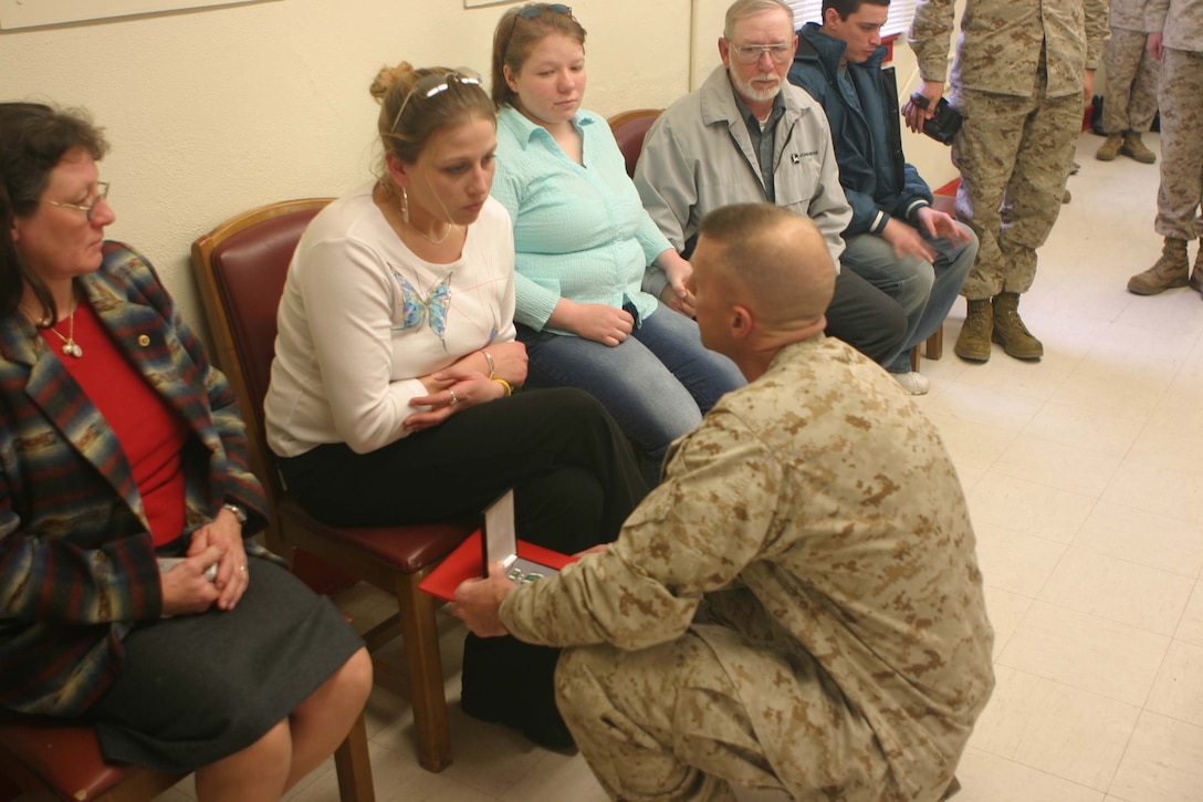 Lt. Col. James G. Kyser, 2/2 Battalion Commanding Officer, presents the Navy and Marine Corps Commendation Medal to Eliza Speer for actions her husband Sgt. Michael R. Speer took during Operation Iraqi Freedom II.