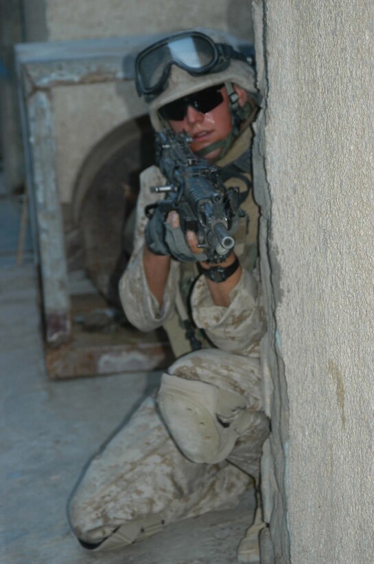 AR RAMADI, Iraq (March 18, 2005) - Nineteen-year-old Lance Cpl. Joshua A. Shores, squad automatic weapon gunner, 1st Squad, 1st Platoon, Company A, of New Richmond, Wis., provides security down a narrow street here while he and his Marines conduct a patrol. The 6-foot-7-inch 200-pound Marine's specialty is kicking doors open and creating entrances where there are none, which makes him a valuable asset when clearing houses. Photo by Cpl. Tom Sloan