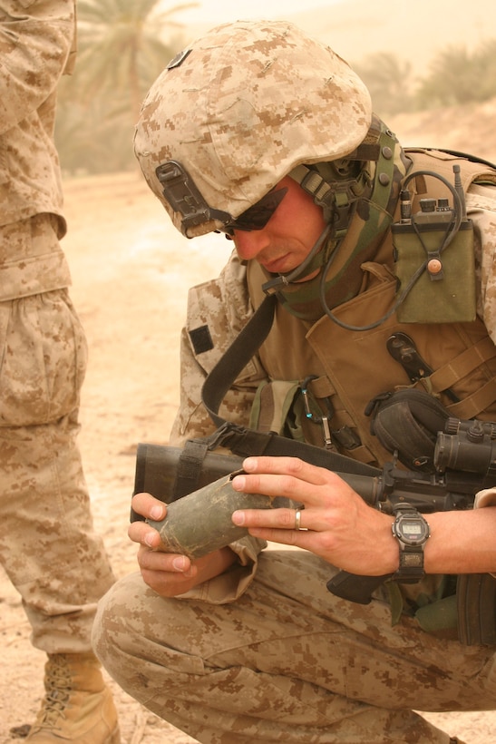CAMP HADITHAH, Iraq -- Sergeant Robert Waltz, a 30-year-old Cleveland, Ohio native and assault section leader with Company L, 3rd Battalion, 25th Marine Regiment inspects a Russian-made rocket he found during a search, April 19.  The 1994 Bishop Hartley High School graduate conducted a search with his platoon for roadside bombs and mortar positions.  The search was prompted by a recent mortar attack that hit the dam.  Two Iraqis were found with a rifle, explosives and bomb making material.  U.S. Marine Corps photo by Sgt. Stephen D'Alessio (RELEASED)