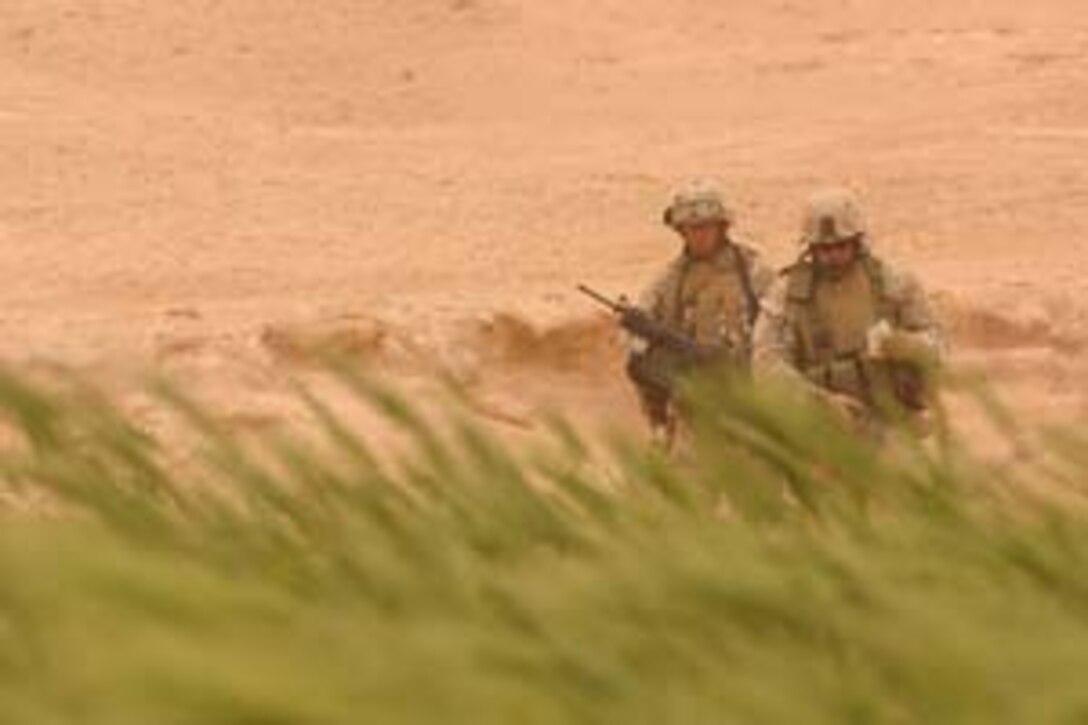 CAMP HADITHAH, Iraq -- Seaman Ruben Cervantez, a 25-year-old Fresno, Calif. native and corpsman with Company L, 3rd Battalion, 25th Marine Regiment looks through a field during a search, April 19.  The 1997 Roosevelt High School graduate searched with his platoon for roadside bombs and mortar positions.  The search was prompted by a recent mortar attack that hit the dam.  Two Iraqis were found with a rifle, explosives and bomb making material.