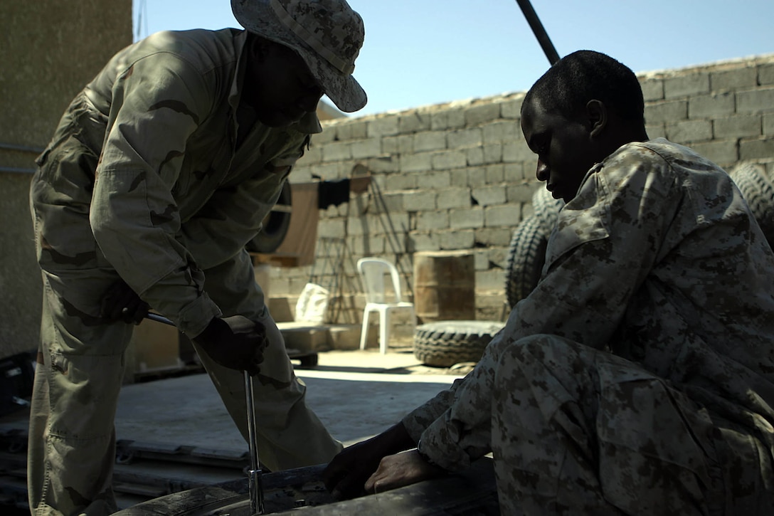 Haditha Dam, Al Anbar, Iraq (May 6, 2005)--Motor transportation operators Lance Cpl. Mackenzy Crawford,21 from Jackson, Miss., and 19-year-old Greenville, Miss., native, Lance Cpl. James W. Buckner repair a tire .(Official USMC Photo by Corporal Ken Melton)