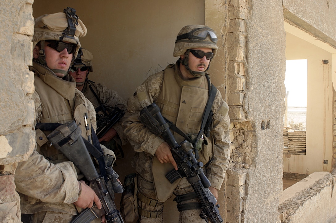 THAR THAR REGION, Iraq - Marines with 2nd Squad, 2nd Platoon, Company B, 1st Battalion, 6th Marine Regiment peek out from an abandoned building here after having searched through it for weapons and explosives.  Company B personnel participated in Operation Dagger, a five-day long effort to rid regions north of Fallujah of insurgent activity.