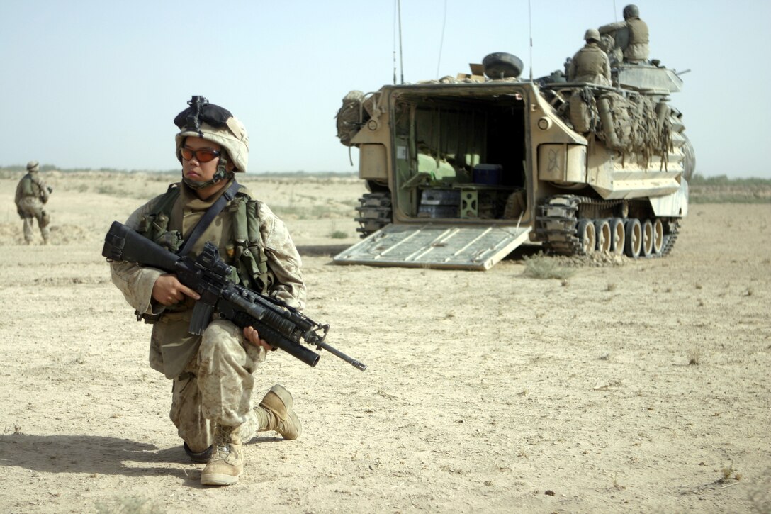 THAR THAR REGION, Iraq - Lance Cpl. Bee Thao, an infantryman with 2nd Squad, 2nd Platoon, Company B, 1st Battalion, 6th Marine Regiment, provides security behind an amphibious assault vehicle here June 19.  Thao's unit was one which participated in Operation Dagger, a five-day long effort to rid regions north of Fallujah of insurgent activity.
