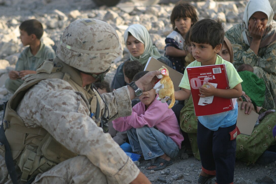 KARABILAH, Iraq- (June 19, 2005)  A Marine passes out school supplies and toys to women and children.  Operation Spear is conducted to destroy insurgency leadership strong points. (Official USMC photo by Cpl Neill A. Sevelius)(RELEASED)