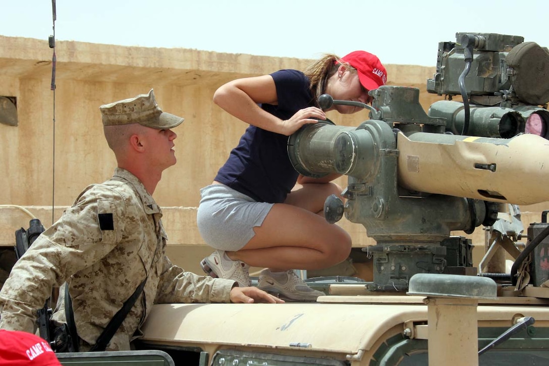 CAMP FALLUJAH, Iraq -- A Marine from Weapons Company, 3rd Battalion, 8th Marine Regiment shows one of the Arizona Cheerleaders their weapons systems mounted on their vehicles.  The cheerleaders took time to answer and ask questions with each group of Marines and Sailors they met with.  Official U.S. Marine Corps photo by Lance Cpl. Athanasios L. Genos