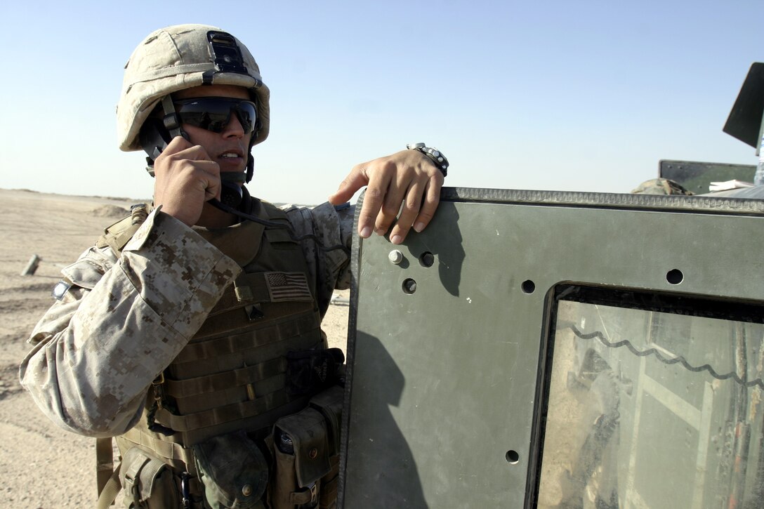 FALLUJAH, Iraq - Corporal Darryl Toquinto, an infantryman with 4th Combined Anti-Armor Team, Weapons Company, 1st Battalion, 6th Marine Regiment, scans the desert horizon for terrorist activity while communicating with members of his platoon on the radio during a recent mission here.  The 24-year-old Gaithersburg, Md. native is a veteran of a 2004 tour of duty in Afghanistan and a Purple Heart recipient who currently serves alongside his unit and Iraqi Security Forces to conduct counterinsurgency operations here.