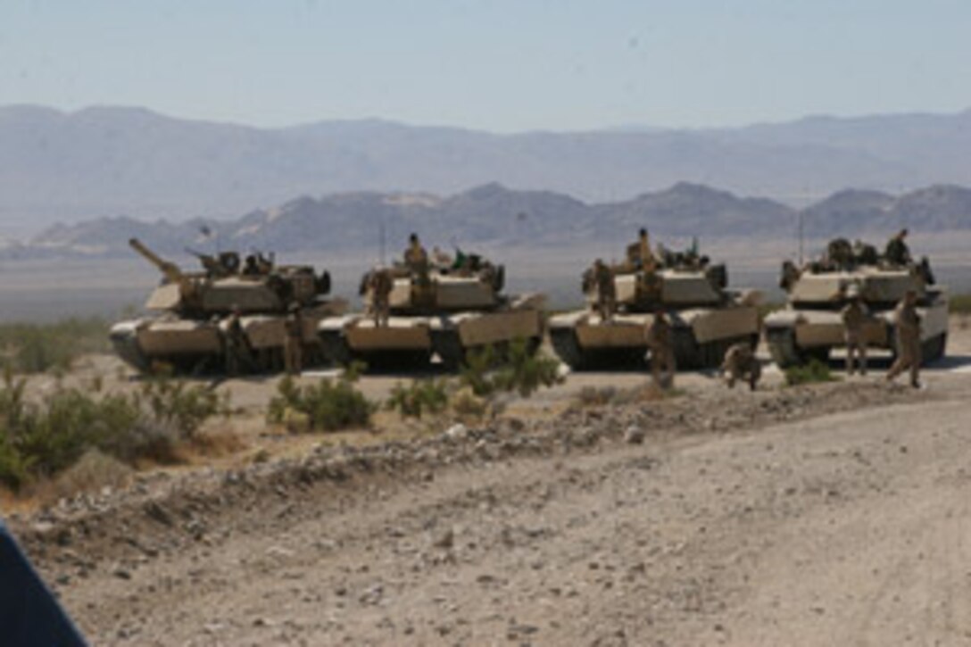 Marines with Delta Company, 1st Tank Battalion, gather around their respective tanks at the firing line at Combat Center?s Range 500 Sept. 19 for last minute adjustments, moments before they shoot four M1028 120 mm Canister Rounds.  Third Platoon, Delta Company, 1st Tank Battalion, fired one canister round per tank, familiarizing their tank crewmen with the destruction the rounds can cause.