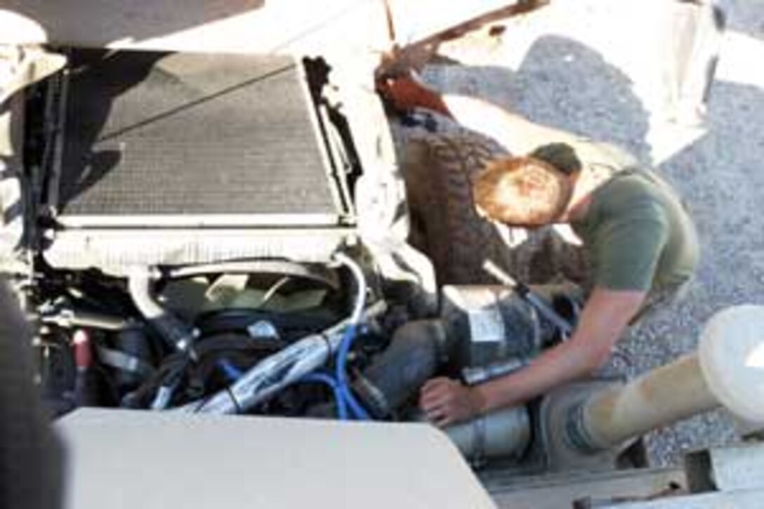 Lance Cpl. Christopher A. Helm, 20, a military policeman with MEU Support Group 15, and native of Omaha, Neb., cleans dry mud off of a humvee. The unit, attached to the 15th Marine Expeditionary Unit (Special Operations Capable) is currently conducting security and stability operations here in the greater Baghdad area.