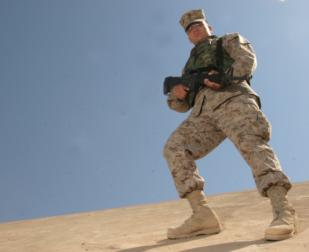 Corporal Kevin Pineda, an administrative clerk with Marine Wing Headquarters-2, poses on one of the original bunkers that was built while Saddam Hussein ruled Al Asad, Iraq.