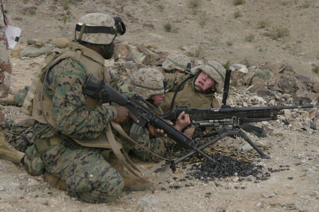 MARINE CORPS AIR-GROUND COMBAT CENTER TWENTYNINE PALMS, Calif. - Machine gunners with Company A, 1st Battalion, 6th Marine Regiment prepare to fire their M240G automatic weapon after reloading.  The unit is participating in a Revised Combined Arms Exercise here to prepare for a deployment to Iraq in March.