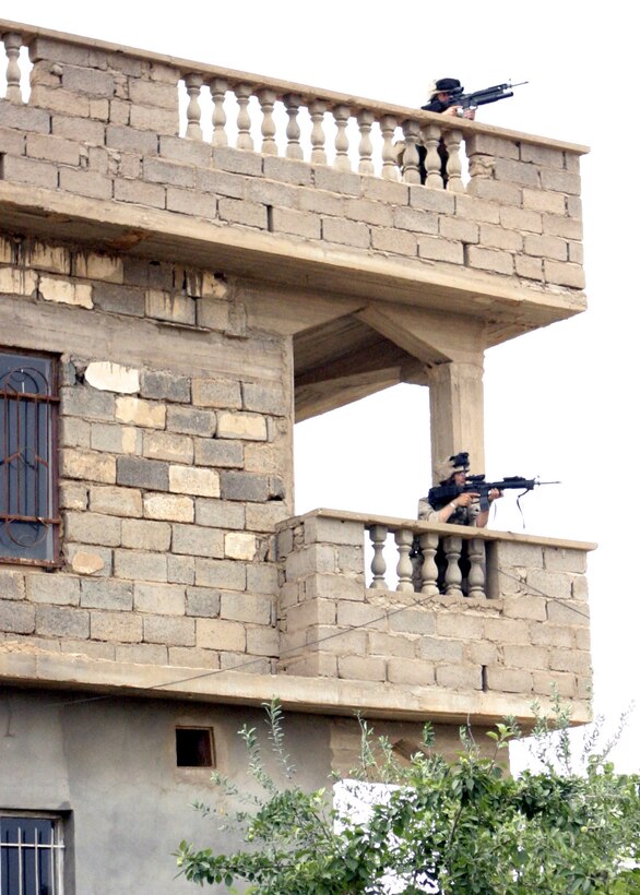 Haqlaniya, Al Anbar, Iraq (April 20, 2005)-- Marines with 3/25 provide overhead secuirty as other Marines search houses in a potentially dangerous area in Haqlanyia.(Official USMC Photo by Corporal Ken Melton)
