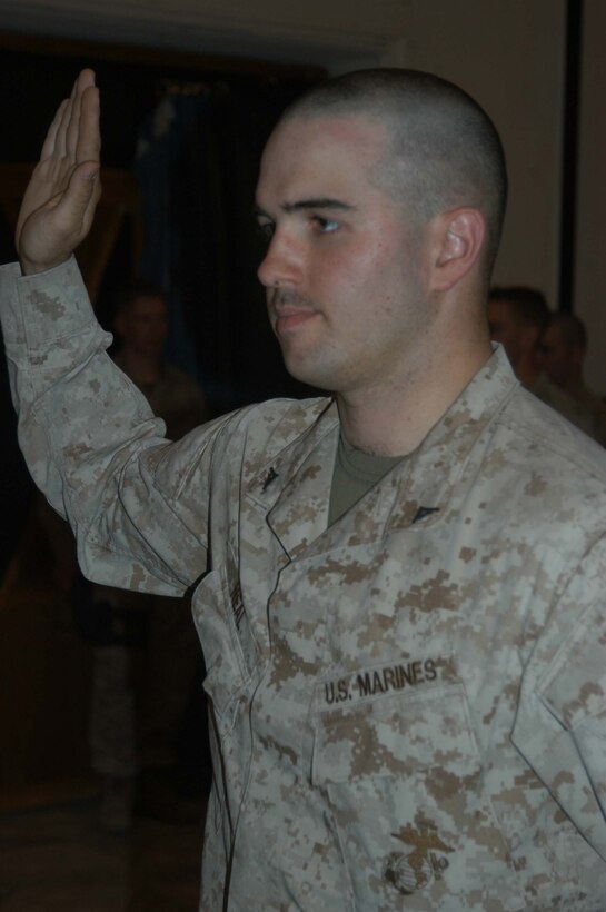 CAMP HURRICANE POINT Ar Ramadi, Iraq (May 20, 2005) - With his right hand raised, Lance Cpl. Michael P. Neal, a machine gunner with 1st Battalion, 5th Marine Regiment's Jump Platoon, takes his oath of reenlistment during a ceremony here. The 21-year-old from Country Club Hills, Ill., swore to devote four more years of service to Corps and country. The 2001 Hillcrest High School graduate received a reenlistment bonus of $19,692, which is tax-free and will be paid in a lump sum. Oliver North and his two-man camera crew covered the event, which will later appear on the Fox News show "Oliver in Iraq." Photo by: Cpl. Tom Sloan