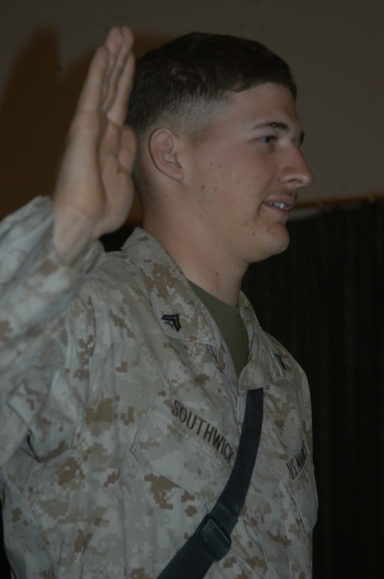 CAMP HURRICANE POINT Ar Ramadi, Iraq (May 20, 2005) - With his right hand raised, Cpl. Nathan S. Southwick, a machine gunner with team leader in 1st Squad, 4th Platoon, Company A, 1st Battalion, 5th Marine Regiment, takes his oath of reenlistment during a ceremony here. The 21-year-old from El Cajon, Calif., swore to devote four more years of service to Corps and country. The 2001 Granite Hills High School graduate received a reenlistment bonus of $21,445.20, which is tax-free and will be paid in a lump sum. Oliver North and his two-man camera crew covered the event, which will later appear on the Fox News show "Oliver in Iraq." Photo by: Cpl. Tom Sloan