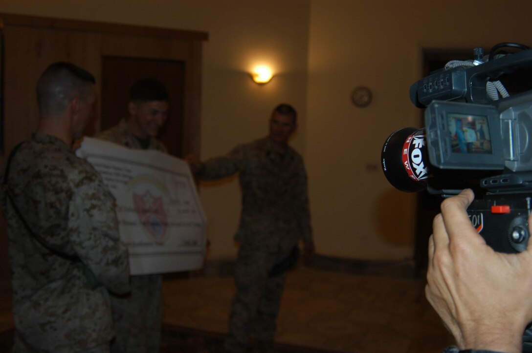 CAMP HURRICANE POINT Ar Ramadi, Iraq (May 20, 2005) - A cameraman with the Fox News show "Oliver in Iraq" videos Cpl. Nathan S. Southwick's reenlistment ceremony, which here held here. The footage will appear on Oliver North's show in a few weeks. The 21-year-old from El Cajon, Calif., swore to devote four more years of service to Corps and country. The 2001 Granite Hills High School graduate received a reenlistment bonus of $21,445.20, which is tax-free and will be paid in a lump sum. Photo by: Cpl. Tom Sloan