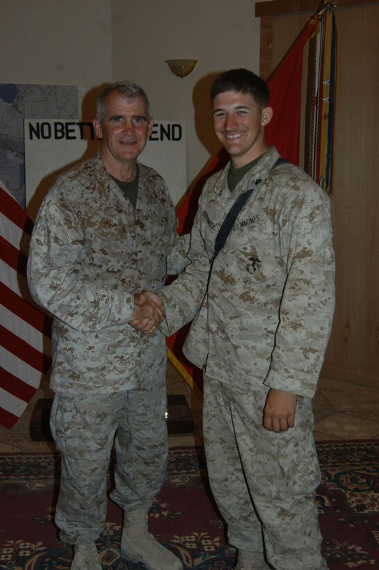 CAMP HURRICANE POINT Ar Ramadi, Iraq (May 20, 2005) -Cpl. Nathan S. Southwick, a machine gunner with team leader in 1st Squad, 4th Platoon, Company A, 1st Battalion, 5th Marine Regiment, shakes hands with Fox News correspondent Oliver North after reenlisting during a ceremony here. The 21-year-old from El Cajon, Calif., swore to devote four more years of service to Corps and country. The 2001 Granite Hills High School graduate received a reenlistment bonus of $21,445.20, which is tax-free and will be paid in a lump sum. North and his two-man camera crew covered the event, which will later appear on the Fox News show "Oliver in Iraq." Photo by: Cpl. Tom Sloan