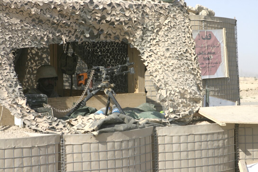 FALLUJAH, Iraq - An Iraqi soldier watches traffic from his post in northern Fallujah's Entry Control Point-2 June 10.  Iraqi Security Forces and 1st Battalion, 6th Marine Regiment personnel man this ECP and prevent weapons, explosives and insurgents from entering the city.