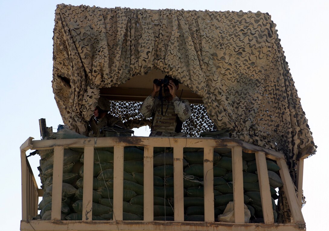 FALLUJAH, Iraq - An Iraqi soldier and a Marine from 1st Battalion, 6th Marine Regiment observe roadways from a tower in northern Fallujah's Entry Control Point-2 June 10. Iraqi Security Forces and 1st Battalion, 6th Marine Regiment personnel man this ECP and prevent weapons, explosives and insurgents from entering the city.