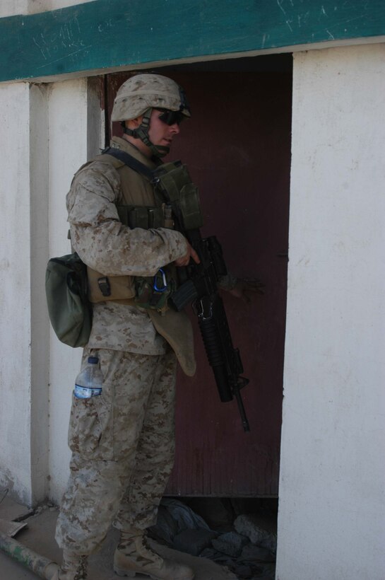 AR RAMADI Iraq (June 14, 2005) - Lance Cpl. Cody M. Eisenbarth, a grenadier with 1st Section, 1st Mobile Assault Platoon, Company W, 1st Battalion, 5th Marine Regiment, looks in a room during mission here. Insurgents attacked the 20-year-old from Sacramento, Calif., and his fellow Marines with an improvised explosive device during a presence patrol they executed in the southern portion of the city. No one was hurt and no vehicles were damaged. Photo by: Cpl. Tom Sloan