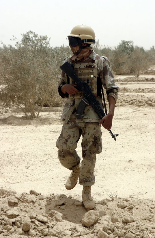 THAR THAR REGION, Iraq - An Iraqi soldier patrols through a field north of Fallujah June 20, searching for buried weapons and explosives.  The Iraqi soldiers assisted U.S. personnel during Operation Dagger, a five-day long effort to rid regions north of Fallujah of insurgent activity.