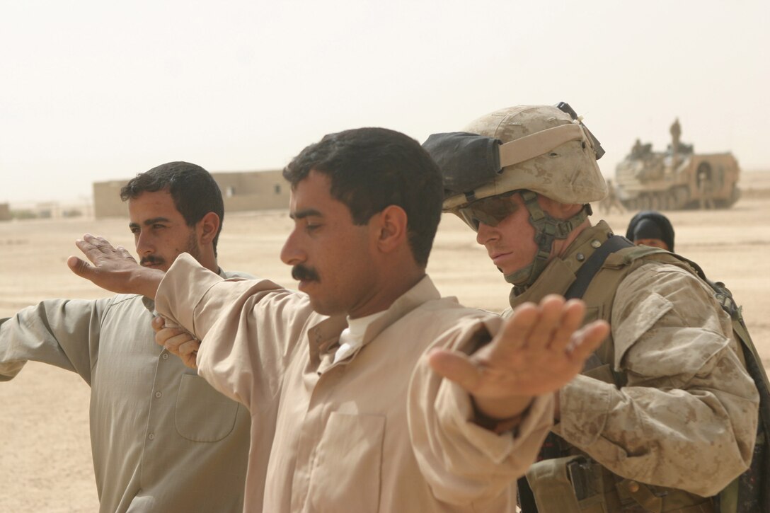 LAKE THARTHAR REGION, Iraq - A Marine with Task Force Hard body searches Iraqi farmers, June 20, in a search for insurgent weapons caches as part of Operation Khandjar (Iraqi for dagger).  The Task Force primarily involved Marines with 1st Battalion, 6th Marine Regiment and went from June 17 through 22.  U.S. Marine Corps photo by Sgt. Stephen D'Alessio (RELEASED)