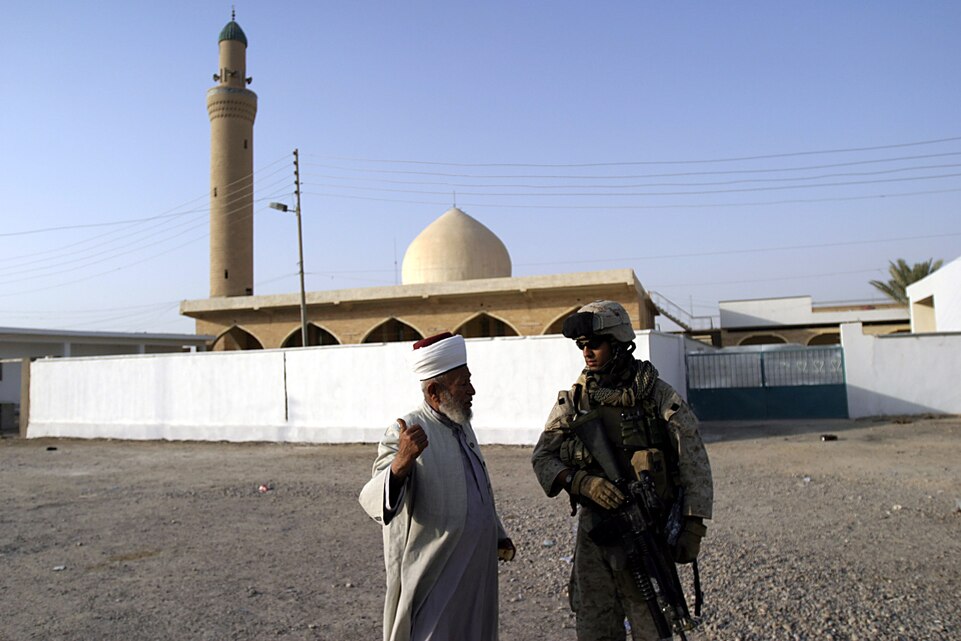 Hit, Al Anbar, Iraq (July 2, 2005)--Lance Cpl. Sajjd H. Rizvi, a fireteam leader with 1st platoon, Lima Co., 3/25 talks to an Imam outside of a Mosque he cannot enter even though he is a Muslim while on patrol during Operation Sword. (Official USMC Photo by Corporal Ken Melton)