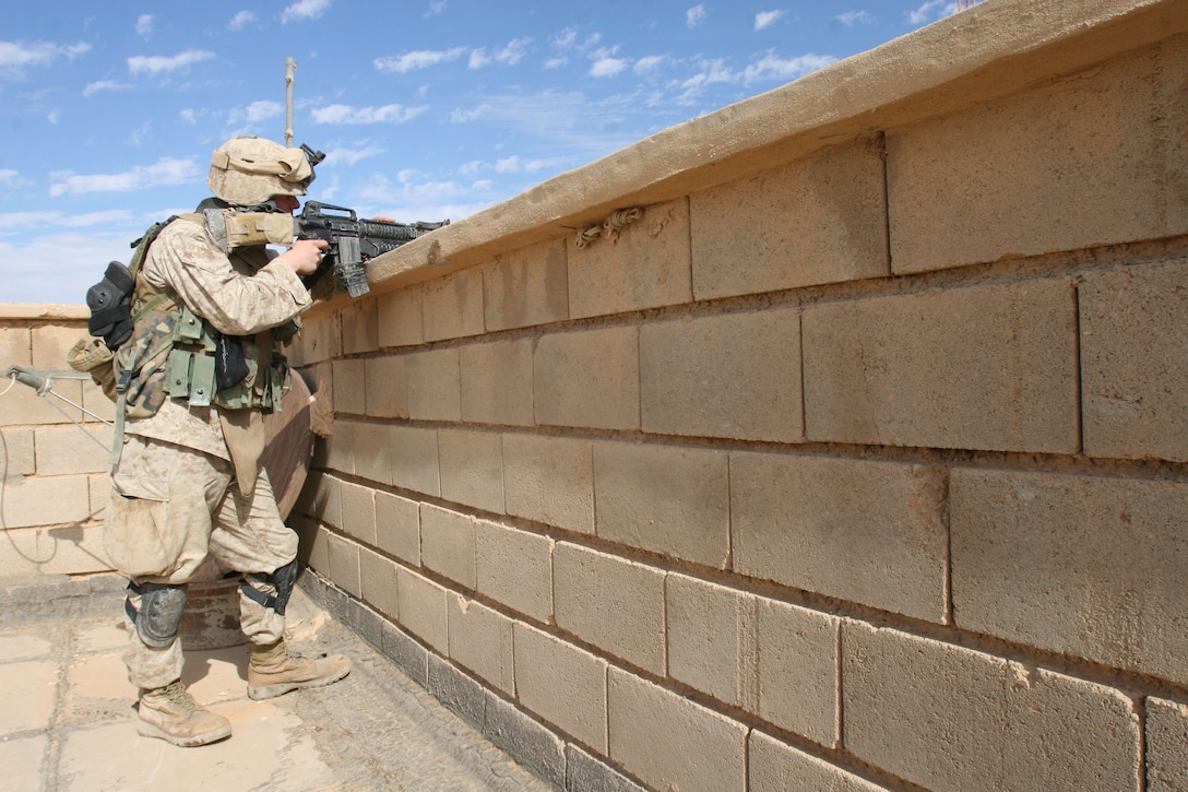 Lance Cpl. Kyle Stewart, a rifleman with Company L, 3rd Battalion, 6th Marine Regiment, provides security from a rooftop, Nov. 6, in Husayba, Iraq.