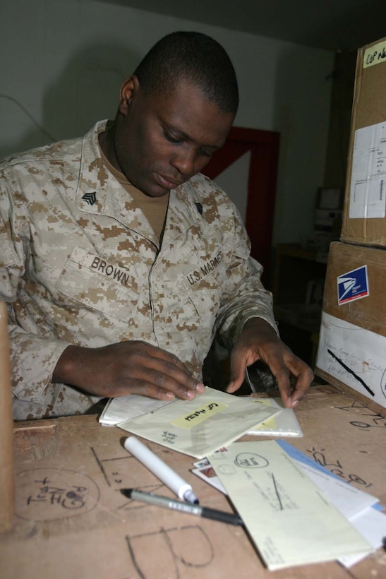 CAMP RIPPER, Iraq (Nov. 18, 2005)  - Denver native Sgt. Dorian D. Brown, a mail and administrative non-commissioned officer with Regimental Combat Team-2, marks mail to be re-routed for Marines on operations. Brown, a recent meritoriously promoted sergeant, keeps morale high on base as he hands out mail on a daily basis. (Official Marine Corps photo by Cpl. Adam C. Schnell)