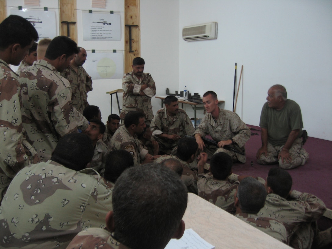 CAMP HABBANIYAH, Iraq - Corporal Russell R. Hall, a wire man with the 2nd Marine Division Training Center, gives a class on the AK-47 to Iraqi Soldiers during the Iraqi Small Arms Weapons Instructors Course held here. Hall is responsible not only for maintaining the units telecommunications system but for assisting with the instruction of Iraqi Security Force personnel who attend various courses here.