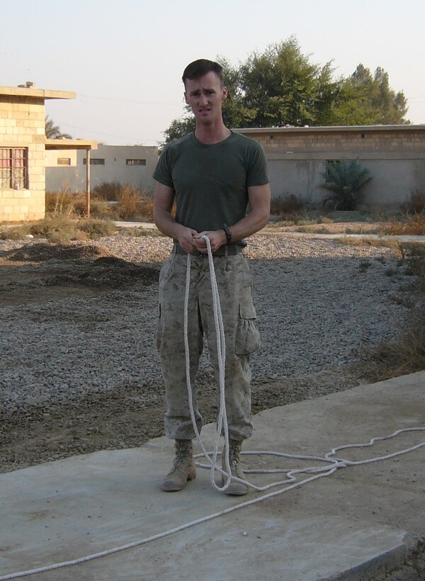 CAMP HABBANIYAH, Iraq - Corporal Russell R. Hall, a wire man with the 2nd Marine Division Training Center, runs wire for the unit's telecommunication system. Hall is responsible not only for maintaining the unit's telecommunications system but for assisting with the instruction of Iraqi Security Force personnel who attend various courses here.