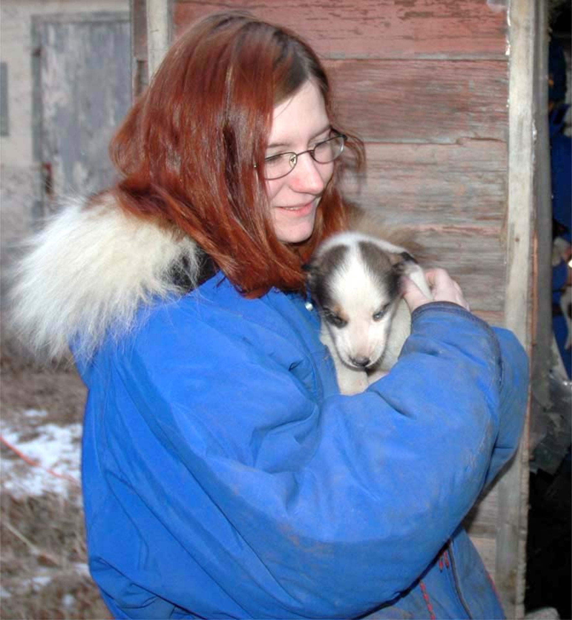 DEERING, N.D. -- Senior Airman Kimberly Williams spends time with of one of the newest sled dogs.  The dog, owned by Senior Airman Mary Lunde, is one of more than a dozen sled dogs that they train with weekly.  Aiman Lunde hopes to one day race in the Iditarod.  The Airmen are assigned to the 5th Munitions Squadron at nearby Minot Air Force Base. (U.S. Air Force photo by Airman 1st Class Danny Monahan)