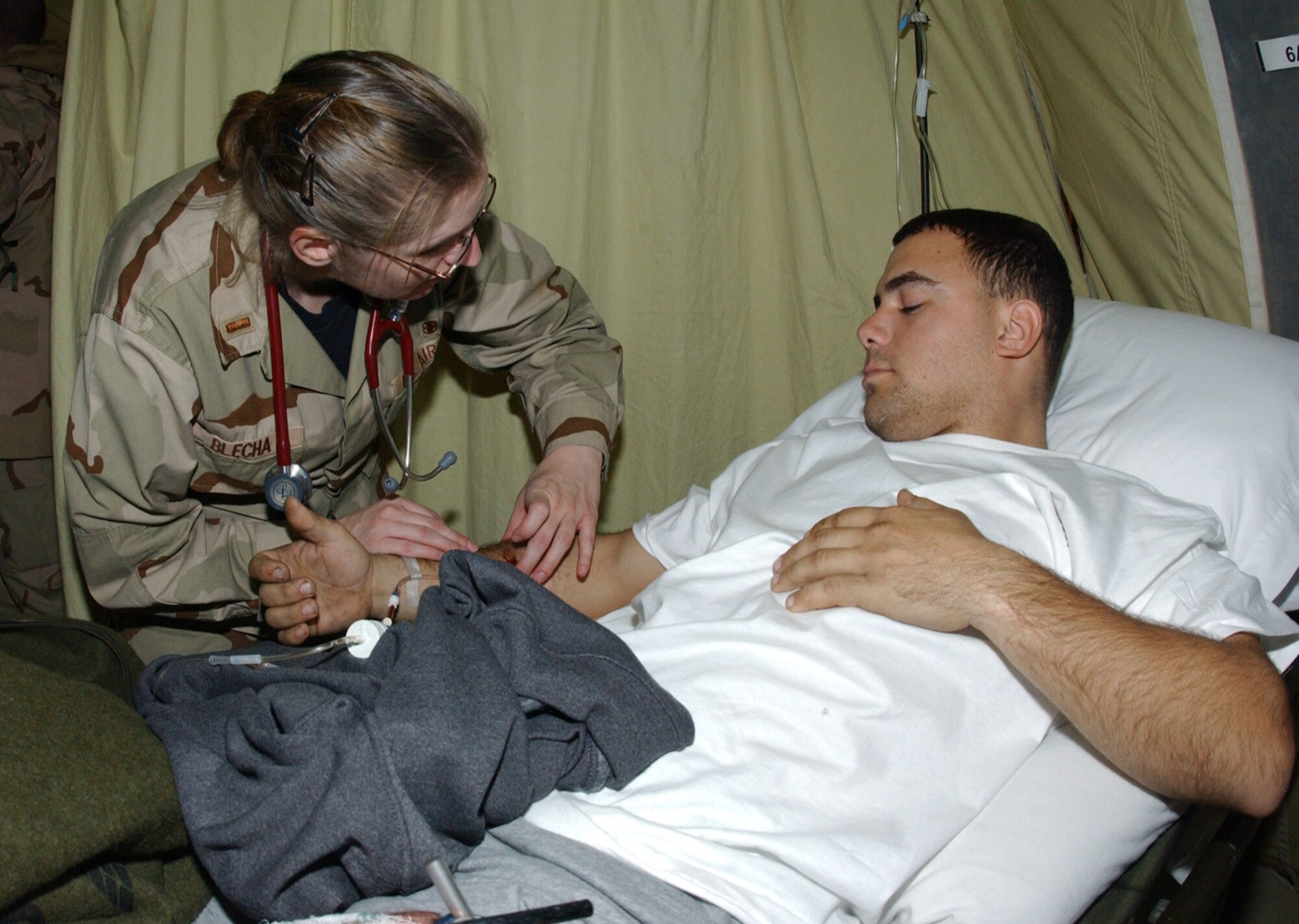 BALAD AIR BASE, Iraq -- 2nd Lt. Tami Blecha performs a neurovascular assessment on Army Spc. Daniel Bartlett at the contingency aeromedical staging facility here Jan. 16.  Specialist Bartlett is a member of the Arkansas Army National Guard deployed as part of the 239th Engineering Company.  Lieutenant Blecha is a clinical nurse deployed to Balad from the 859th Medical Operations Squadron at Lackland Air Force Base, Texas.  (U.S. Air Force photo by Tech. Sgt. Marc Barnes)