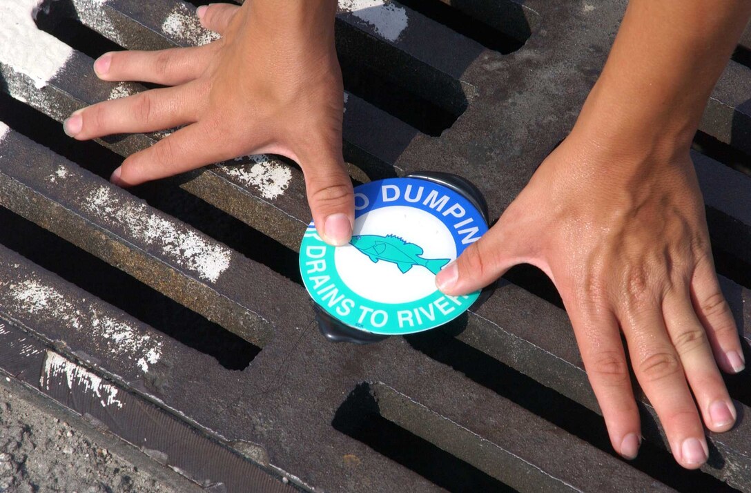 A group of Boy Scouts participated in an environmental awareness project Aug. 20 by adhering anti-dumping stickers onto storm water run-off drains in the commissary parking lot, around French Creek, and in a few residential areas around base.