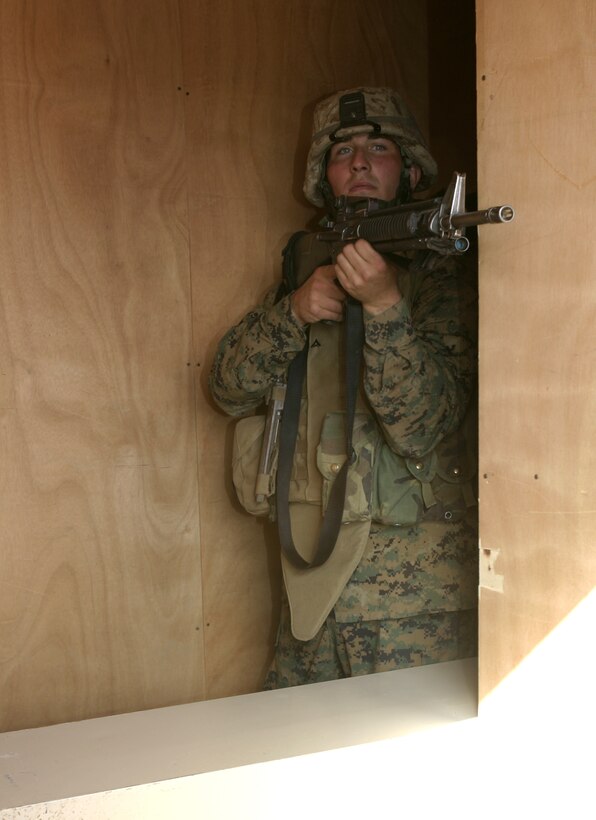 MARINE CORPS AIR-GROUND COMBAT CENTER TWENTYNINE PALMS, Calif. - A Marine with Company A, 1st Battalion, 6th Marine Regiment aims in from behind a window at the Military Operations in Urban Terrain facility here.  The unit practiced room-clearing maneuvers to prepare for an upcoming deployment to Iraq in March.
