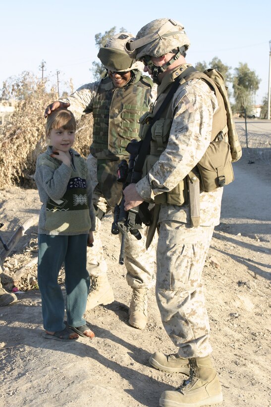 FALLUJAH, Iraq - A Marine with Company C, 1st Battalion, 6th Marine Regiment and an Iraqi translator speak with a local girl at the entry control point outside northwestern Fallujah.  The unit and local Interim Iraqi Forces are working closely to keep insurgents and weapons out of the city.