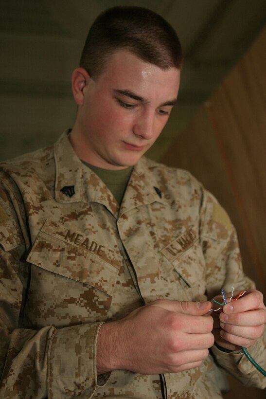 CAMP BLUE DIAMOND, AR RAMADI, Iraq -- Sergeant Sammie R. Meade, a 21-year-old Manchester, N.H. native and tactical data network specialist with Headquarters Battalion, 2d Marine Division, connects computer network wires in the combat operations center, March 21.  U.S. Marine Corps photo by Sgt. Stephen D'Alessio (RELEASED)