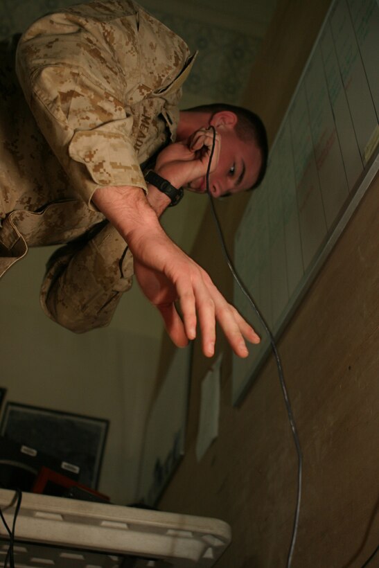 CAMP BLUE DIAMOND, AR RAMADI, Iraq -- Sergeant Sammie R. Meade, a 21-year-old Manchester, N.H. native and tactical data network specialist with Headquarters Battalion, 2d Marine Division, leads wire through the combat operations center to network a computer, March 21.  U.S. Marine Corps photo by Sgt. Stephen D'Alessio (RELEASED)