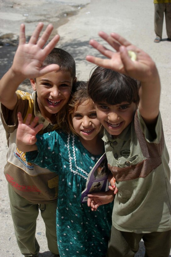 AR RAMAMDI, Iraq (May 21, 2005) - Three Iraqi children seem happy to have Marines passing through their neighborhood here. Marines with 1st Platoon, Company C, 1st Battalion, 5th Marine Regiment, often patrol this area and give the children candy and other gifts. The children have come to associate the Marines' presence with presents. Photo by: Cpl. Tom Sloan