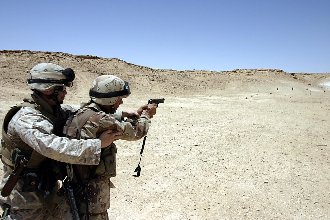 Camp Ripper,Al Asad, Iraq (May 21, 2005) -  A member of the reconnaissance company of the 7th Iraqi Security Battalion gets a assistance on how to properly fire the M-9. (Official USMC photo by Cpl. Ken Melton)