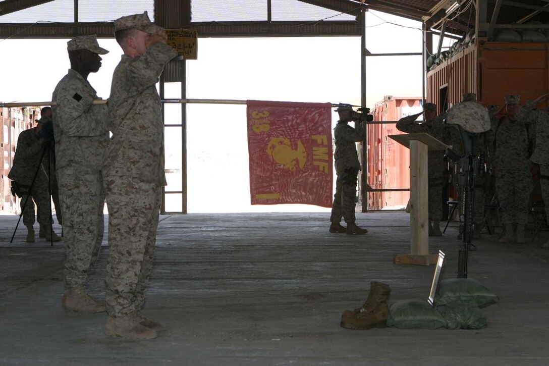 CAMP FALLUJAH, IRAQ -- The company guidon is held at present arms while TAPS is being played during a memorial service held May 21 for fallen Marine, Lance Cpl. John T. Schmidt.  The Marines of India Company, 3rd Battalion, 8th Marine Regiment came together and shared memories and scriptures as they honored their friend and Marine who they lost to an enemy attack at Observation Post 2.  Official U.S. Marine Corps photo by Lance Cpl. Athanasios L. Genos